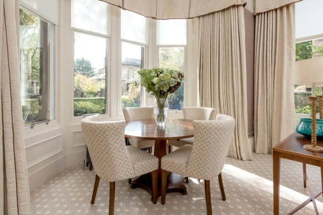 The drawing room has a small dining area in the bay window.