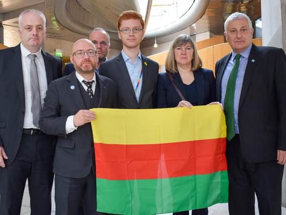 Scottish Green MSPs with flag of Rojava, the autonomous region of north and east Syria.