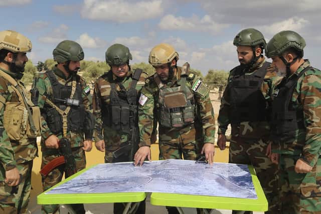 Turkish-backed forces from the Free Syrian Army look at a map during military manoeuvres in preparation for the Turkish incursion against Syrian Kurdish fighters.