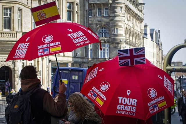 Guides offer city tours to tourists on the Royal Mile in Edinburgh. Picture: Andy Buchanan/AFP