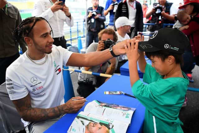 Lewis Hamilton with a young fan at an autograph signing session ahead of the F1 Grand Prix of Japan at Suzuka. Picture: Clive Mason/Getty