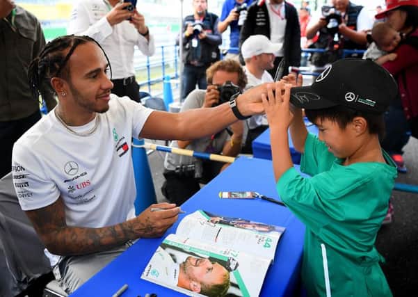 Lewis Hamilton with a young fan at an autograph signing session ahead of the F1 Grand Prix of Japan at Suzuka. Picture: Clive Mason/Getty
