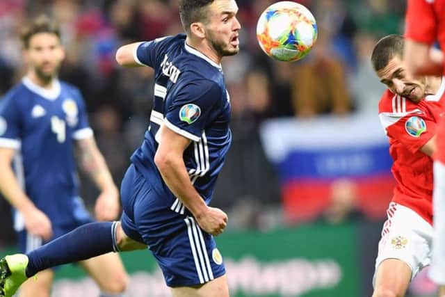 John McGinn battles for possession during the 4-0 loss in Russia.