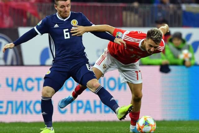 John Fleck battles for possession during Scotland's match with Russia.