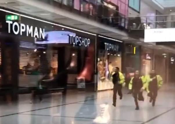 A video grab shows police running through the Arndale Centre in Manchester where at least four people have been treated after a stabbing incident. Picture: @GrizzleMarine /PA Wire