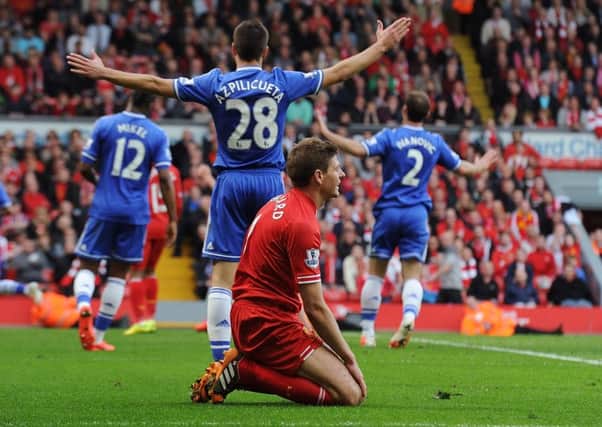 A dejected Steven Gerrard sinks to his knees as Chelsea celebrate their 2-0 victory at Anfield in 2014, a match which had been billed as the league  title decider. Gerrards slip had led to the Blues crucial opening goal. Picture: Liverpool FC via Getty