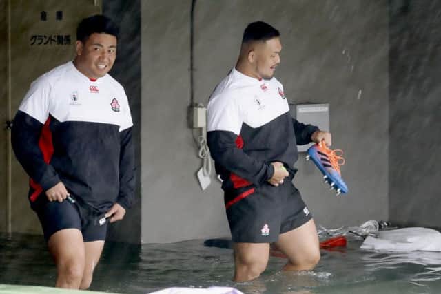 Japan's rugby team players wade through a flooded walkway in Tokyo as the team practices. Pic: Yuki Sato/Kyodo News via AP