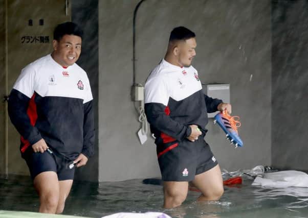 Japan's rugby team players wade through a flooded walkway in Tokyo as the team practices. Pic: Yuki Sato/Kyodo News via AP