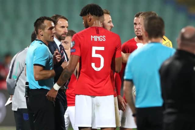 England manager Gareth Southgate and defender Tyrone Mings in discussion with referee Ivan Bebek amid racist chanting by a section of Bulgaria supporters. Picture: PA Wire