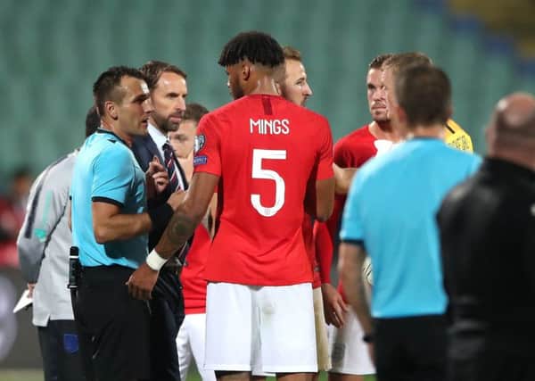 England manager Gareth Southgate and defender Tyrone Mings in discussion with referee Ivan Bebek amid racist chanting by a section of Bulgaria supporters. Picture: PA Wire