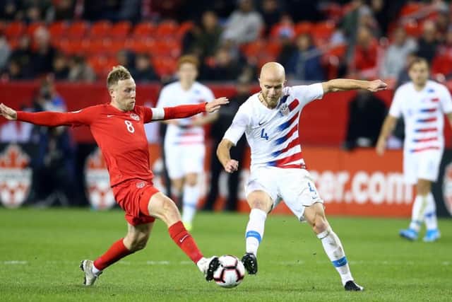 Canada captain Scott Arfield battles for the ball with US midfielder Michael Bradley
