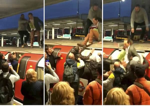 The moment an angry mob of commuters dragged Extinction Rebellion protestors off the top of a London Underground train at Canning Town station, east London.