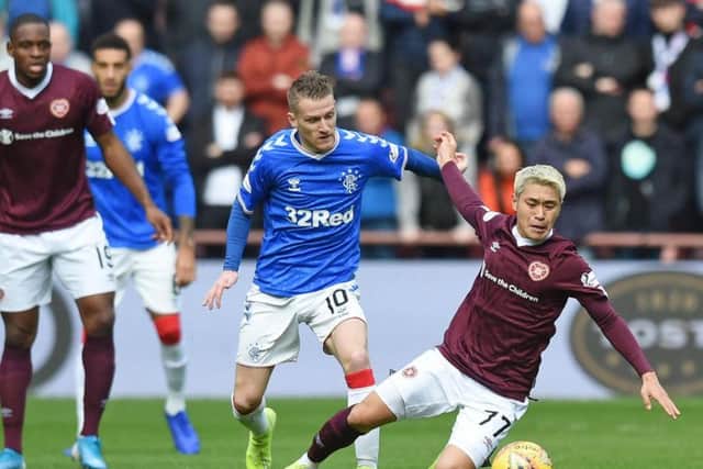 Hearts goalscorer Ryo Meshino battles for the ball with Rangers midfielder Steven Davis