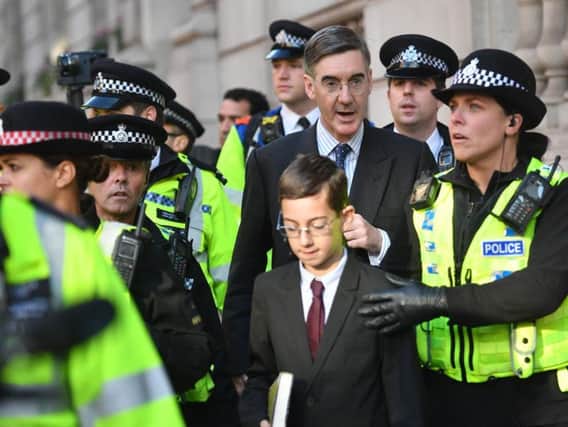Jacob Rees-Mogg with his son Peter Theodore Alphege as they are escorted by police