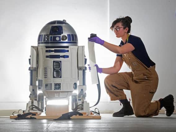 Jessie Giovane Staniland of V&A Dundee strikes a pose similar to Princess Leia in Star Wars as she takes a close look at the R2-D2 prop which will feature in its forthcoming robots exhibition.