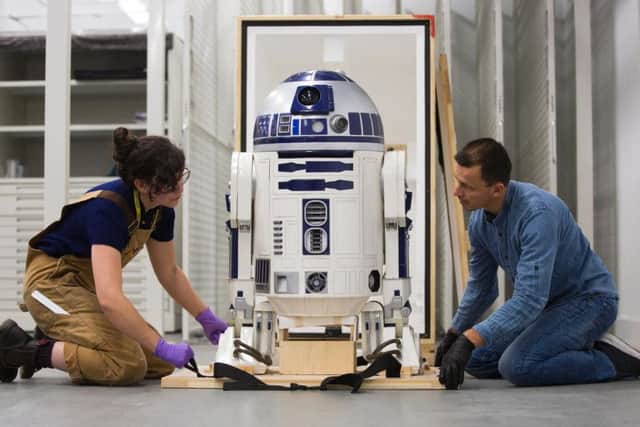 Jessie Giovane Staniland of V&A Dundee and Patrick Luetzelschwab of the Vitra Design Museum in Germany inspect R2-D2 on its arrival in Dundee.