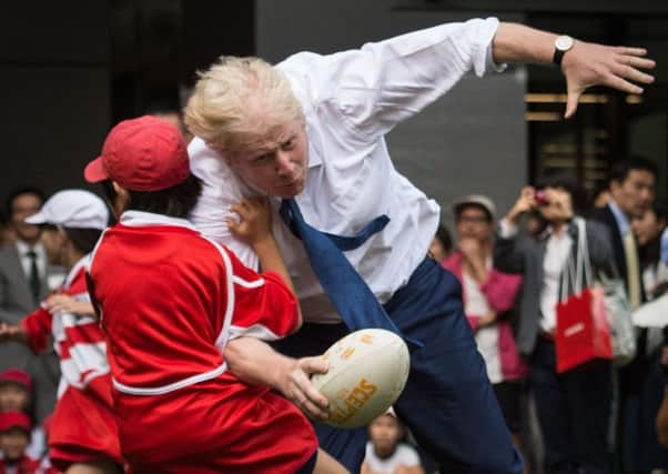 Red card? Born front-row forward Boris Johnson shows his skills as he accidentally takes out a small child in Japan (Picture: Stefan Rousseau/PA Wire)