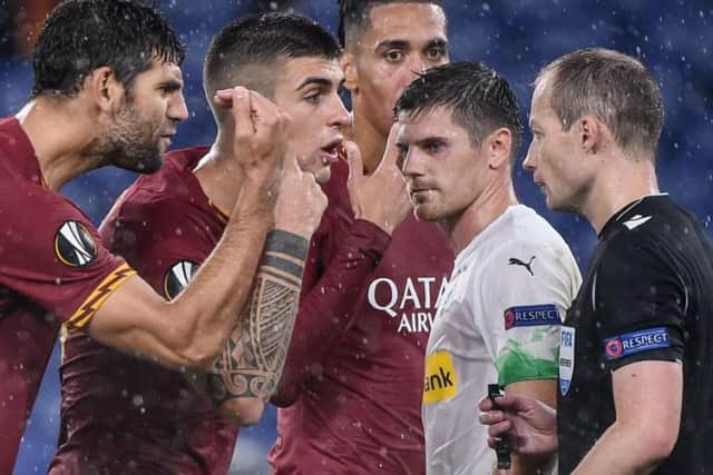 Federico Fazio (left) and Gianluca Mancini of Roma argue with Scottish referee Willie Collum.