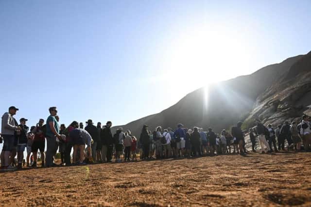 People queued to have one last attempt at climbing the Uluru, which will now be closed to climbers. Picture: Lukas Coch/AAP