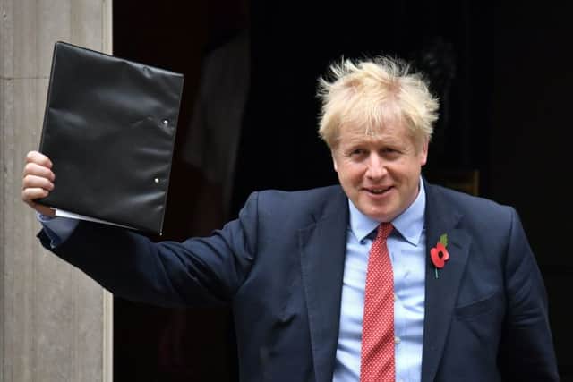 Prime Minister Boris Johnson waves a folder as he leaves 10 Downing Street (Picture: Dominic Lipinski/PA Wire)