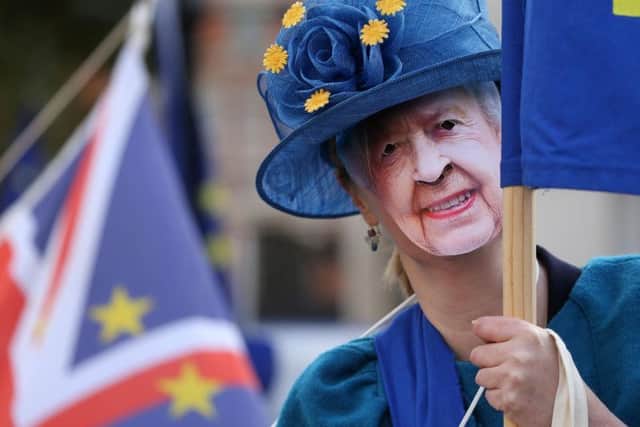 A pro-EU demonstrator wearing a mask of the Queen