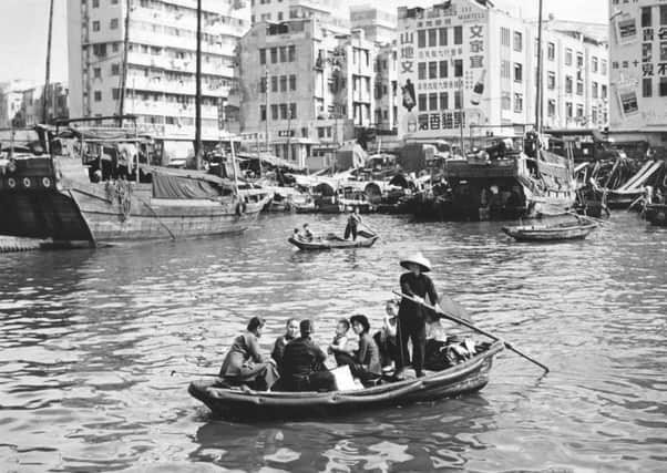 A group of people being ferried across a stretch of water in Hong Kong. (Photo by Leonard G. Alsford/Fox Photos/Getty Images)