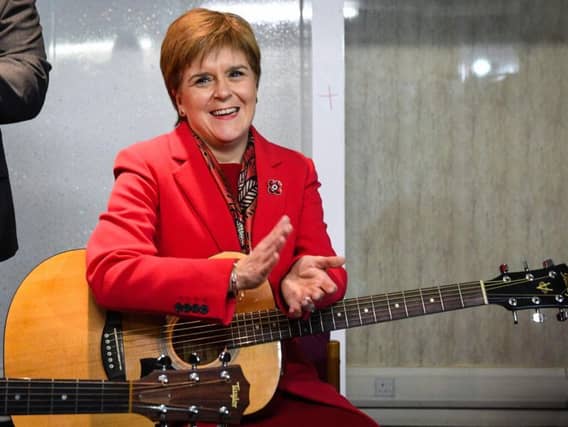 The First Minister was on the campaign trail in Dalkeith on Tuesday where she joined folk musicians in a rendition of Monkees hit I'm a Believer. Picture: AFP/Getty Images