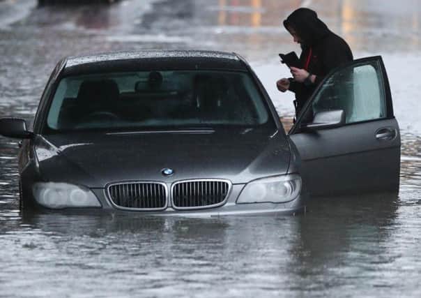 A man with car in a flooded Sheffield street after torrential rain in the area. Picture: Danny Lawson/PA Wire