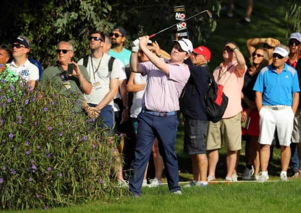 Bob MacIntyre plays his second shot on the thirteenth from behind a bush. Picture: Warren Little/Getty Images