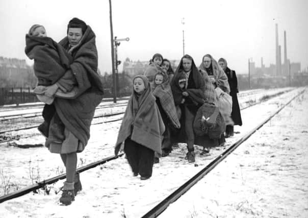 A handful of survivors from the 150 refugees who left Lodz in Poland two months earlier, headed for Berlin, arrive in the devastated German capital in December 1945. They are following railway lines on the outskirts of the city in the hope of being picked up by a British train. (Picture: Fred Ramage/Getty Images)