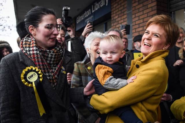 Scottish Nationalist Party (SNP) leader Nicola Sturgeon (R) holds a baby as she campaigns with SNP candidate Catriona MacDonald on November 12, 2019 in Edinburgh. (Photo by ANDY BUCHANAN/AFP via Getty Images)