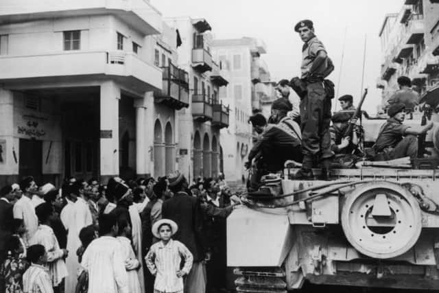 Egyptians crowd around a British tank in Port Said during the Suez Crisis in 1956. (Picture: Fox Photos/Hulton Archive/Getty Images)