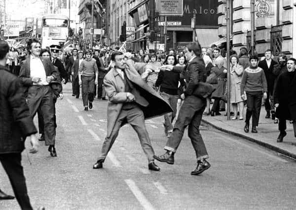 A youth slashes the coat of Special Branch police officer George Johnston with an open razor during a pro-IRA march through Glasgows Renfield Street in 1971 (Picture: Allan Milligan)