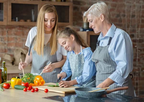 Adults teach a young girl how to cook healthy food