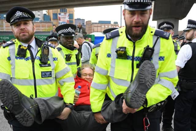 Police officers arrest an activist at London City Airport last month