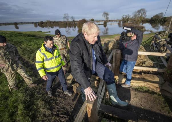 Boris Johnson climbs a stile as he is shown work carried out by the army by Lt Col Tom Robinson from the Light Dragoons and Oliver Harmar, Yorkshire Area Director of the Environment Agency. Picture: Danny Lawson/Getty