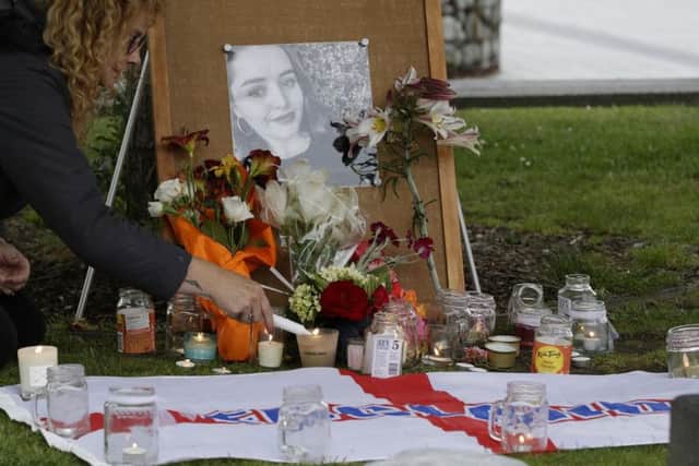 A woman lights candles during a candlelight vigil for murdered British tourist Grace Millane at Cathedral Square in Christchurch.