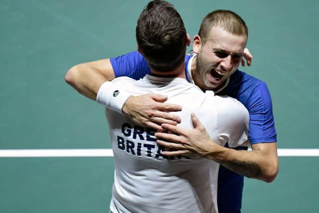 Dan Evans celebrates with Great Britain's captain Leon Smith. Picture: AFP via Getty Images