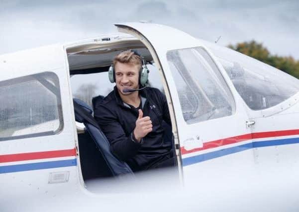 Scotland Sevens player and pilot Tom Brown gives the thumbs up ahead of take-off.
