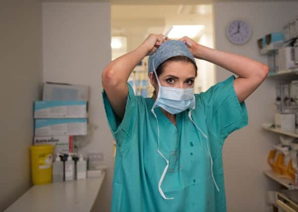 A surgical care practitioner prepares for the operating theatre (Picture: Oli Scarff/AFP/Getty Images)