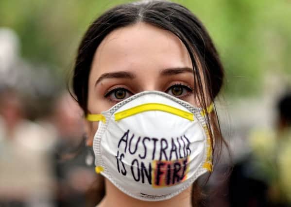 A demonstrator makes a point at a climate protest rally in Sydney on Wednesday as bushfire smoke chokes the city, causing health problems to spike. (Picture: Saeed Khan/AFP via Getty Images)