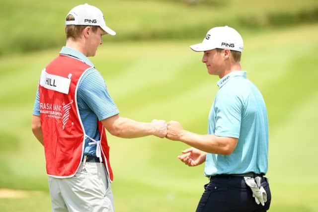 Calum Hill celebrates holing a birdie putt at the last in the second round of the AfrAsia Bank Mauritius Open with his caddie and brother, Ian. Picture: Getty Images