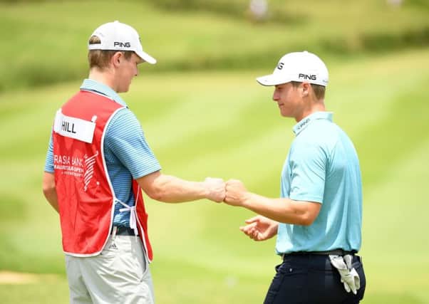 Calum Hill celebrates holing a birdie putt at the last in the second round of the AfrAsia Bank Mauritius Open with his caddie and brother, Ian. Picture: Getty Images