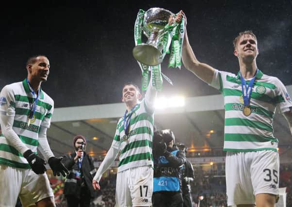 Ryan Christie holds aloft the Betfred trophy with  Kristoffer Ajer.
