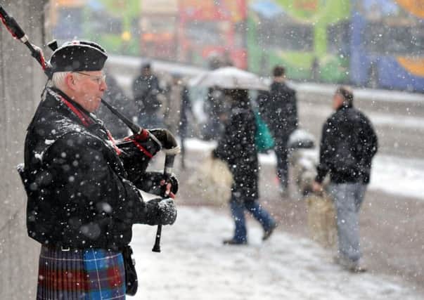 A bagpipe plays through a snowstorm in central Edinbrugh