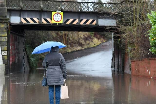 A woman surveys flooding in East Kilbride