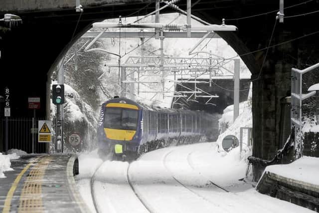 A train travels through a snow-covered Falkirk High station