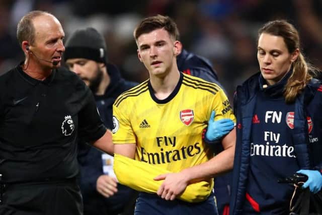Kieran Tierney is helped off the park after falling awkwardly during Arsenal's Premier League clash with West Ham at the London Stadium