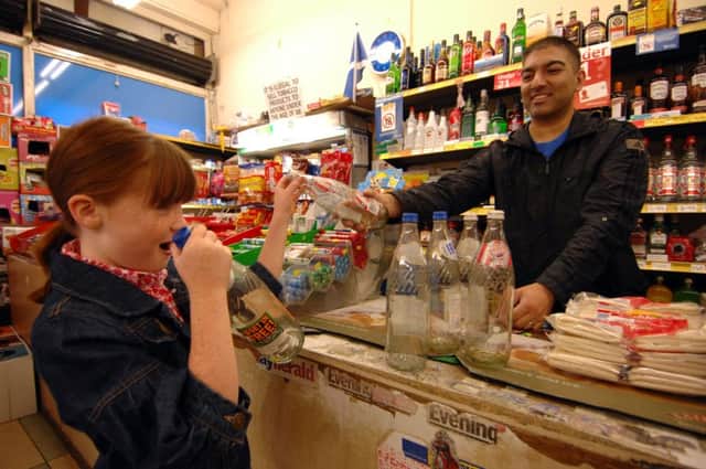 A young girl returns glass bottles to her local shop and gets cash in return
