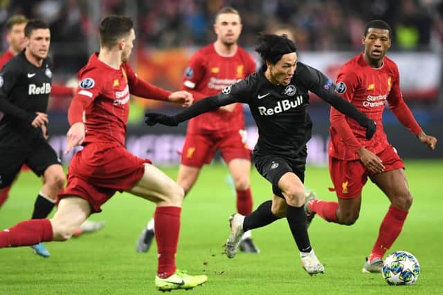 Salzburg's Japanese midfielder Takumi Minamino vies with Liverpool's Andrew Robertson. Picture: Joe Klamar/AFP via Getty